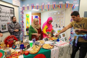 People gathered around a table laden with food at an event.
