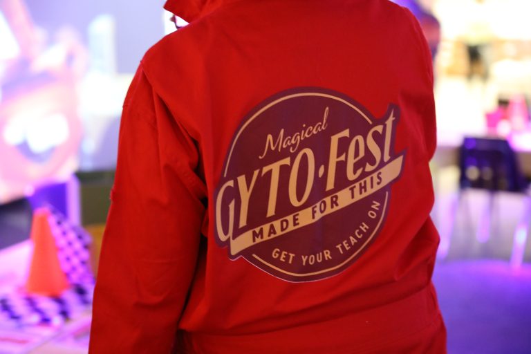 Person wearing a red jacket with a white logo that reads "Crypto Fest" on the back.