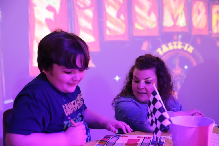 Two people are sitting at a table playing a game.