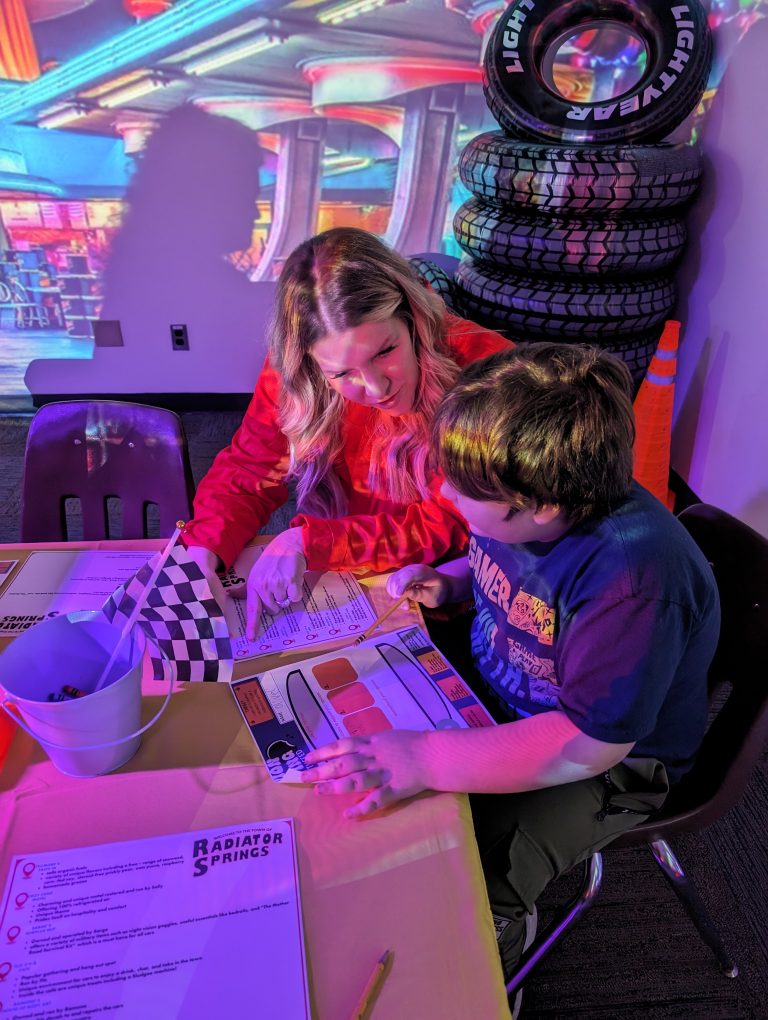 Woman and child sitting at a table working on a project.
