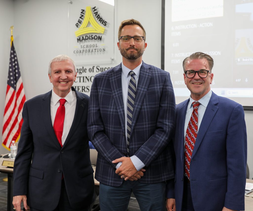 Three men standing in suits smiling
