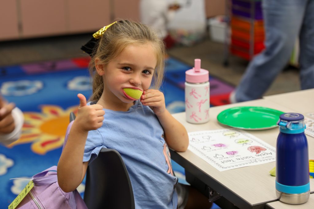Student tries an apple.