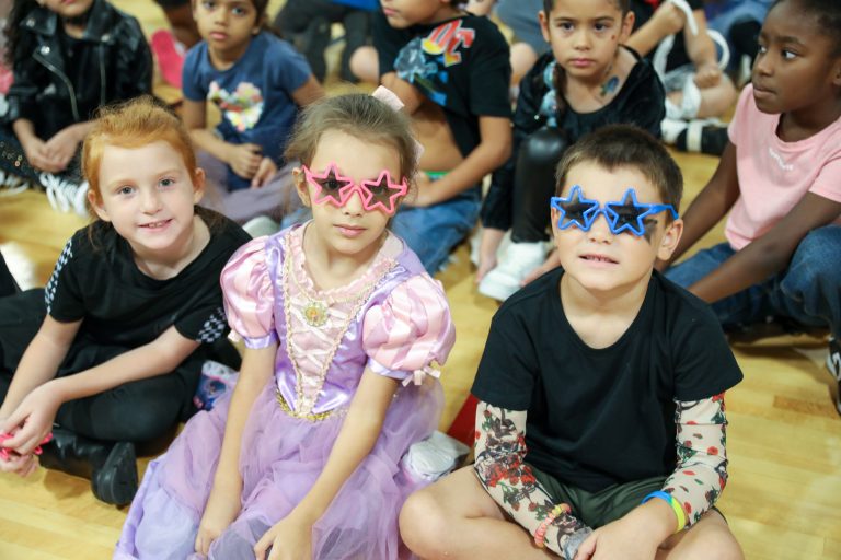 Children in colorful costumes posing for a photo.