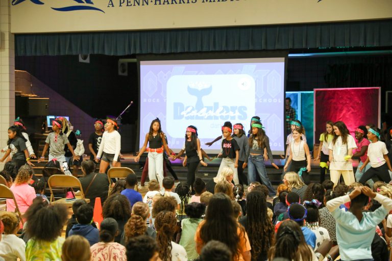Children performing on stage in school event.