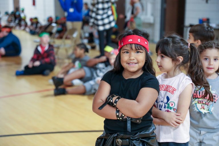 Children in a gymnasium, posing for a picture.