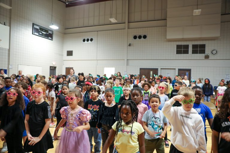 Children in costumes performing on stage.