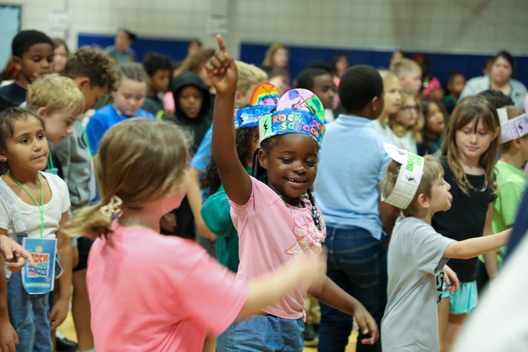 Children in colorful party hats at a birthday party.