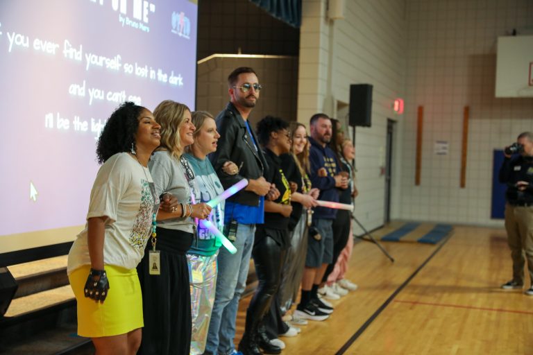 People standing in a group on stage at an event, smiling and posing for the camera.
