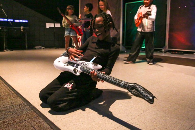 Person playing a guitar on stage.