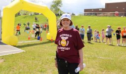 woman in maroon t-shirt that reads Running is Elementary