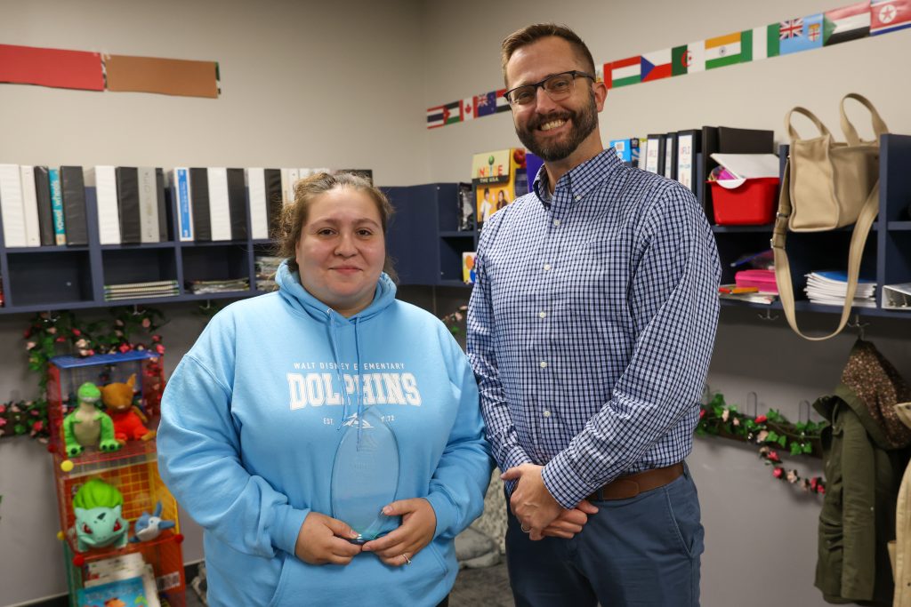 Man standing next to a woman in a room filled with bookshelves.