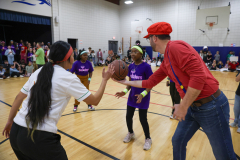 Man in red shirt holding a basketball.