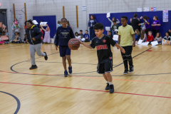 Boys playing basketball on a gym court.