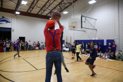 Man shooting basketball in gymnasium.
