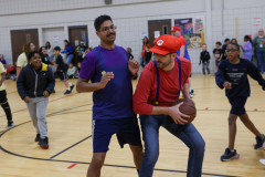 Two men playing basketball in a gymnasium.