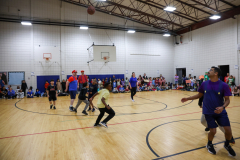 People playing basketball in a gymnasium.